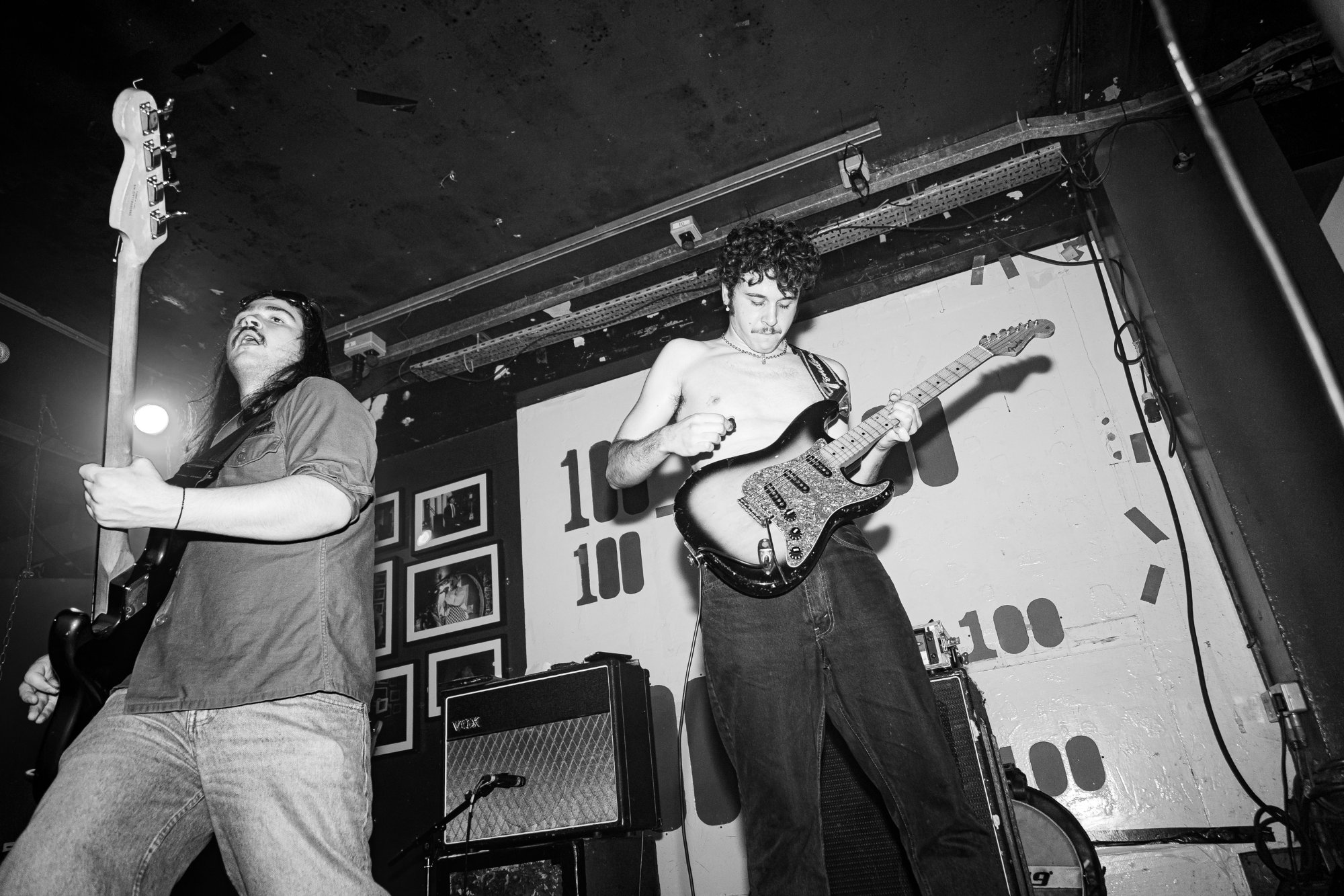 Townhouses performing live at the 100 Club — bassist and guitarist, black and white